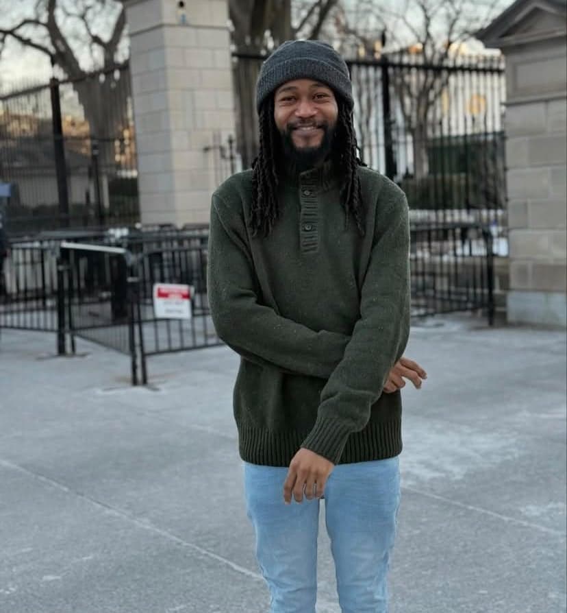Chef Alonzo Llewellyn smiling outdoors in a green sweater and knit hat