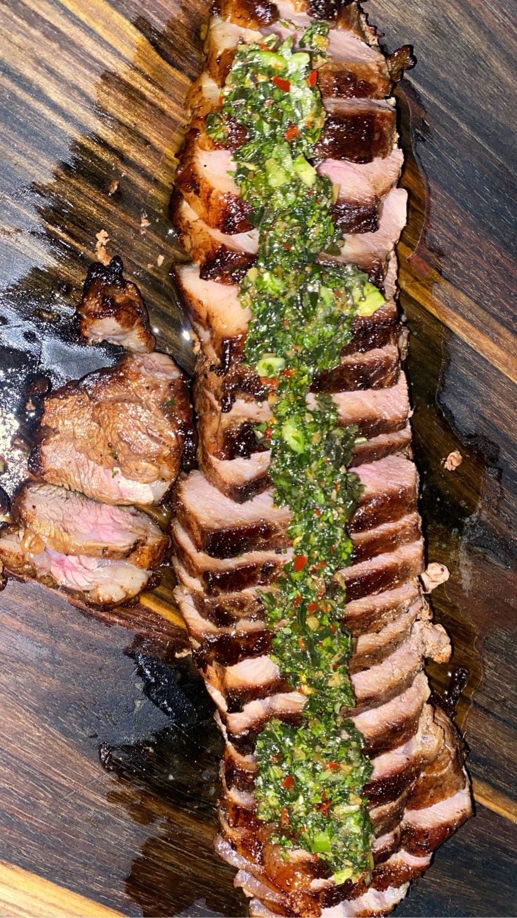 Sliced grilled pork topped with a green herb sauce