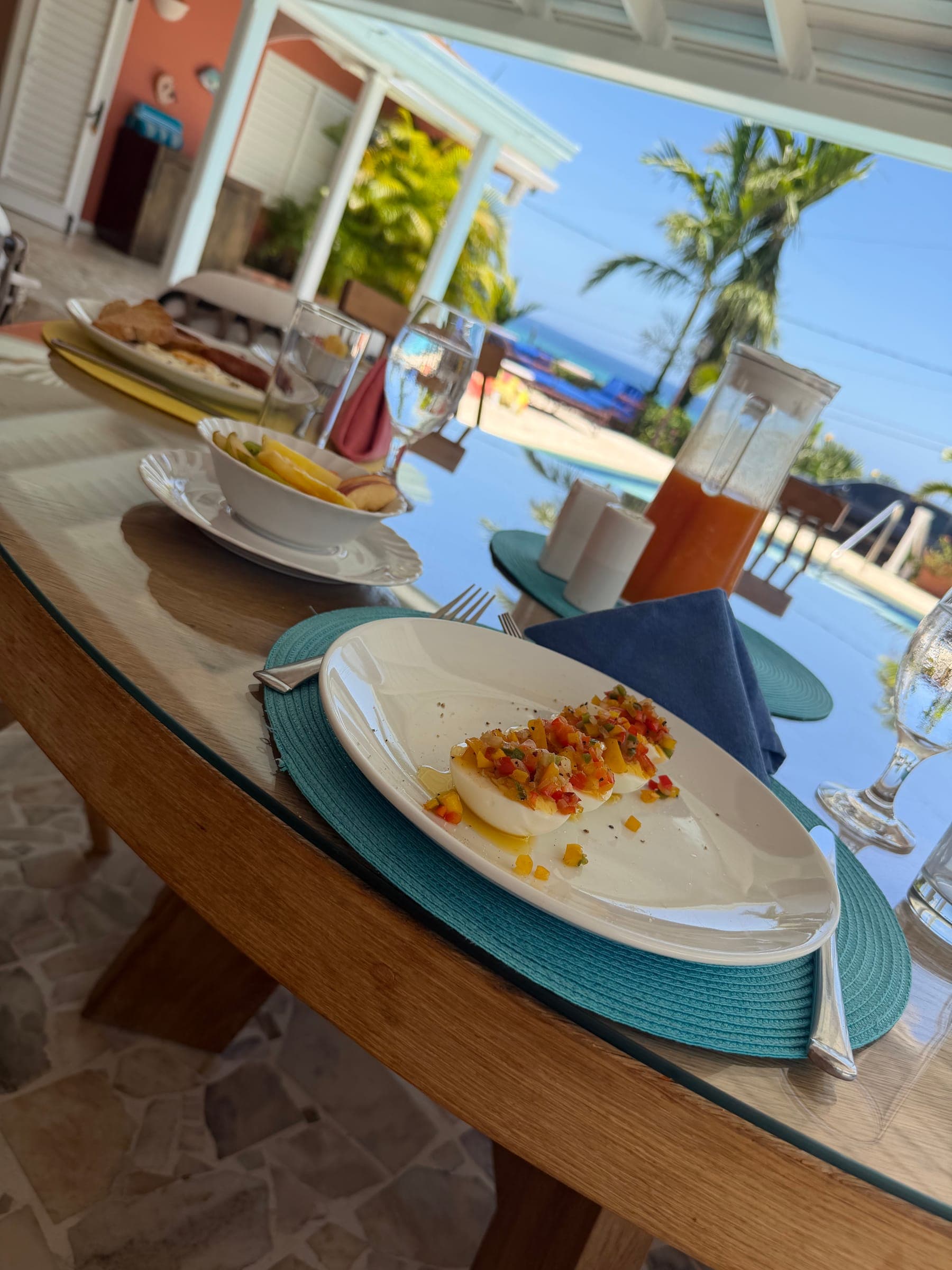 Poolside villa table set for lunch with an ocean view