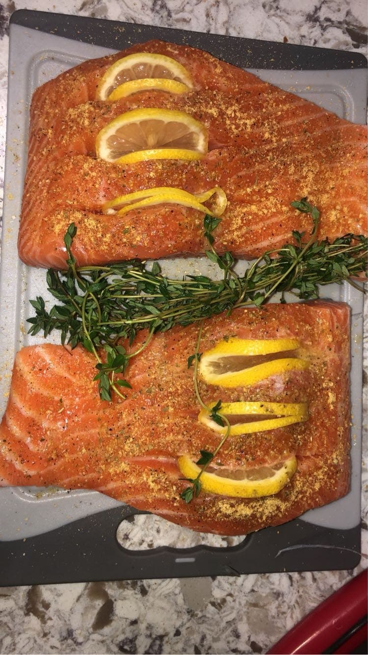 Raw salmon fillets dressed with lemon and fresh herbs