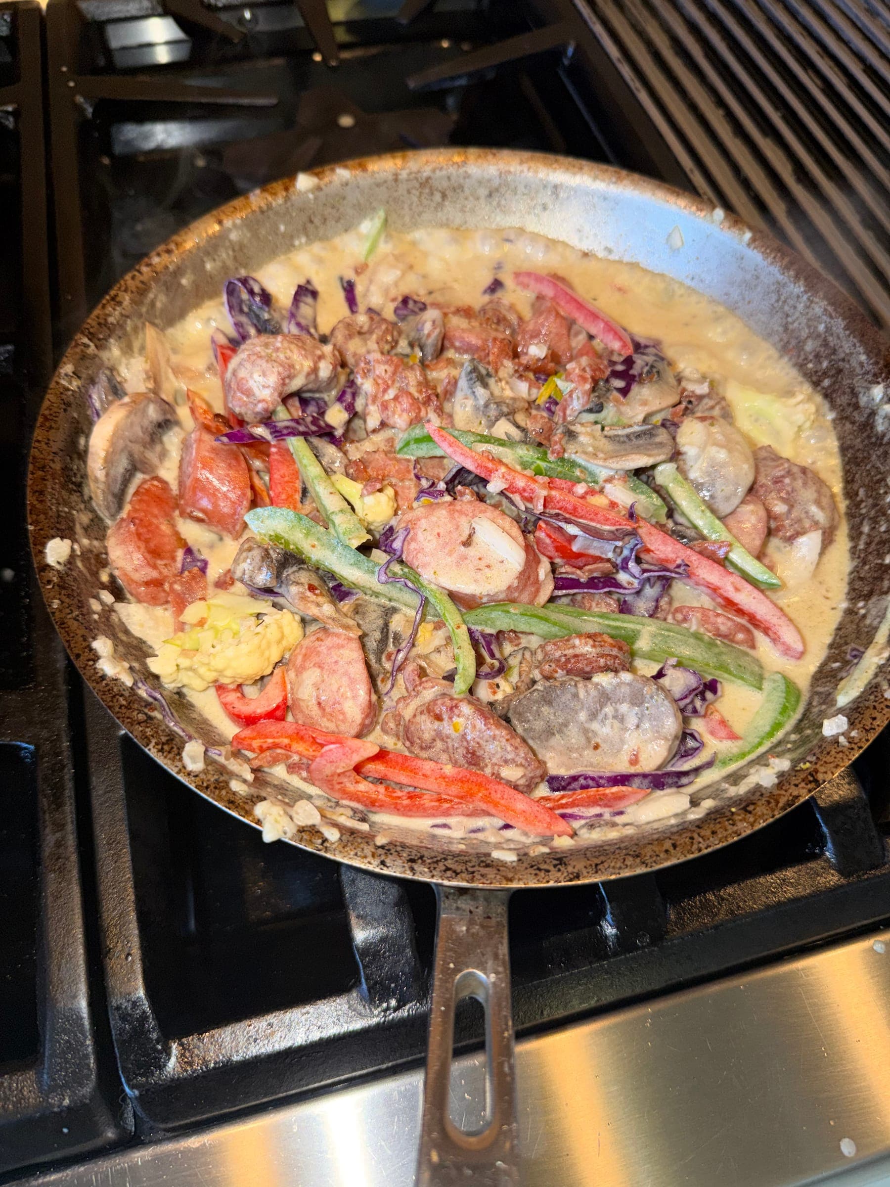Creamy seafood pasta with peppers finishing in the pan