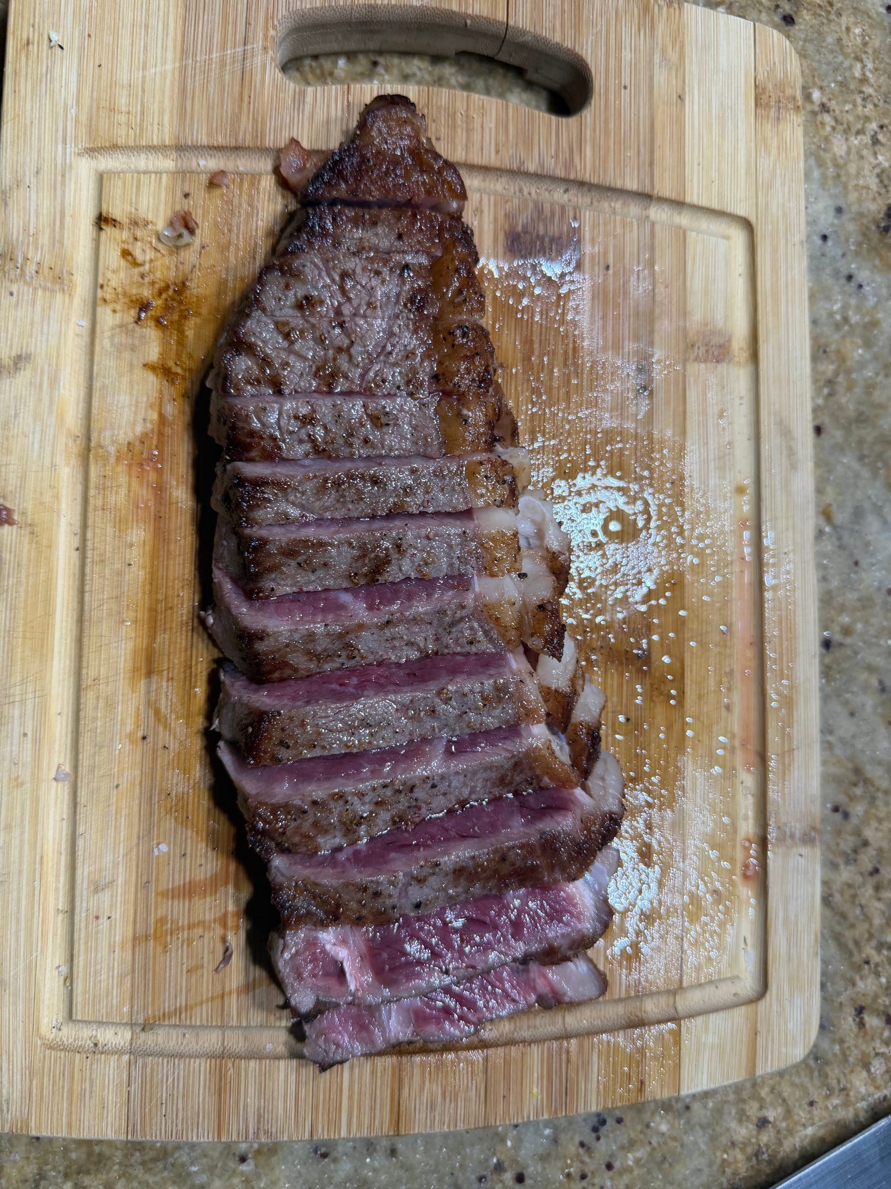 Sliced grilled steak resting on a wooden board